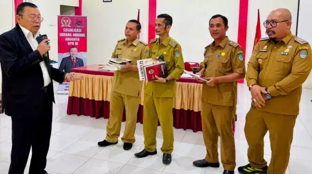 Cornelis menyerahkan buku hukum desa kepada kepala desa di Sengah Temila